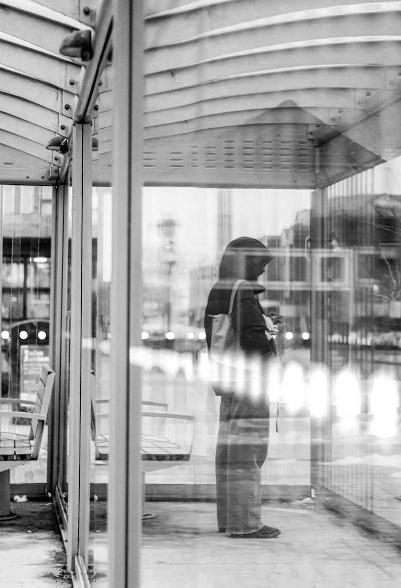 Person stands inside a bus stop shelter