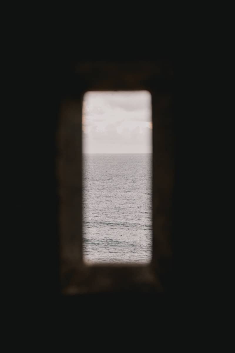 View of the ocean through a dark opening.