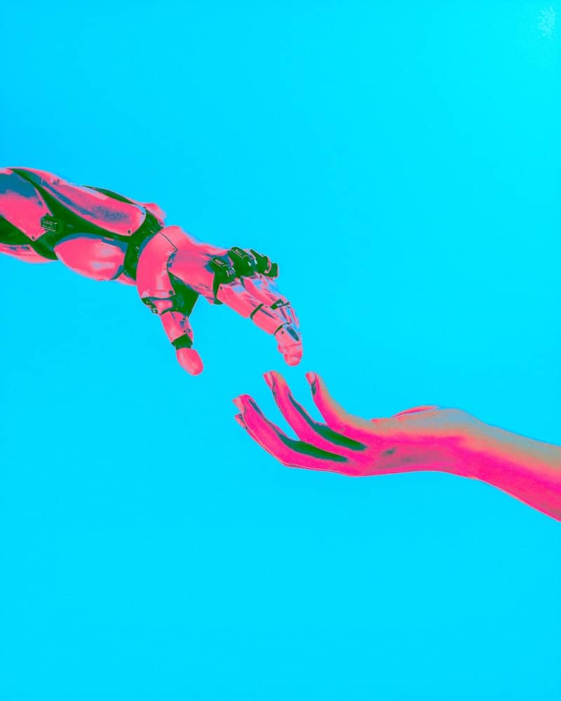 robot and human hands reaching toward each other