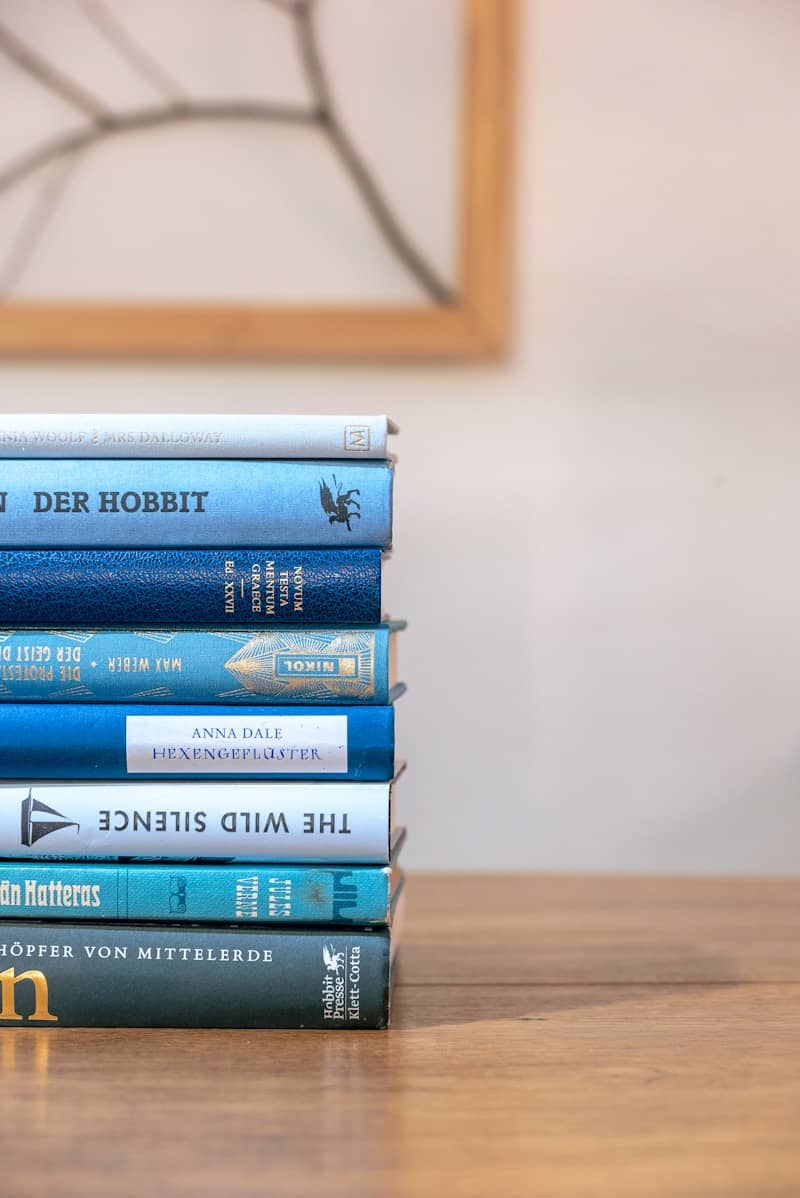 a stack of books sitting on top of a wooden table