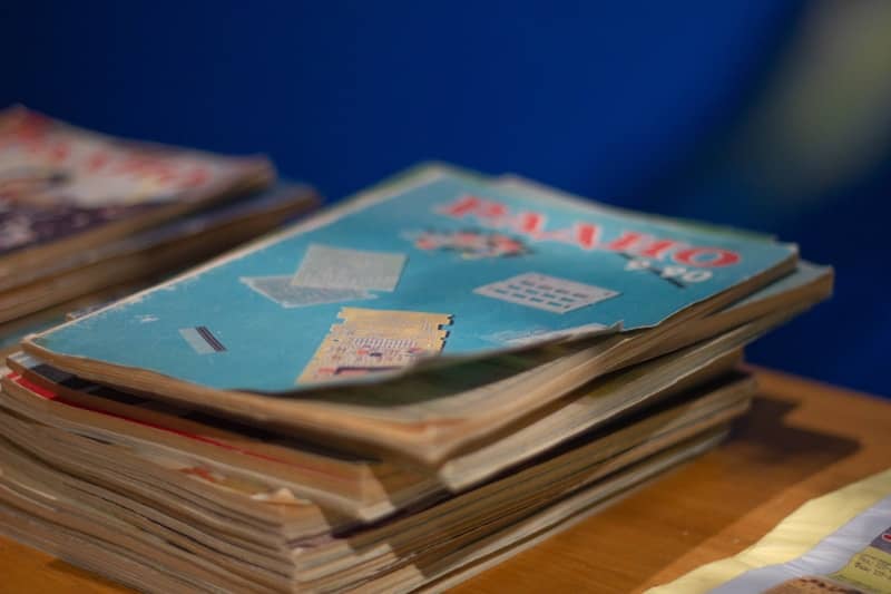 Stack of old magazines on a table.