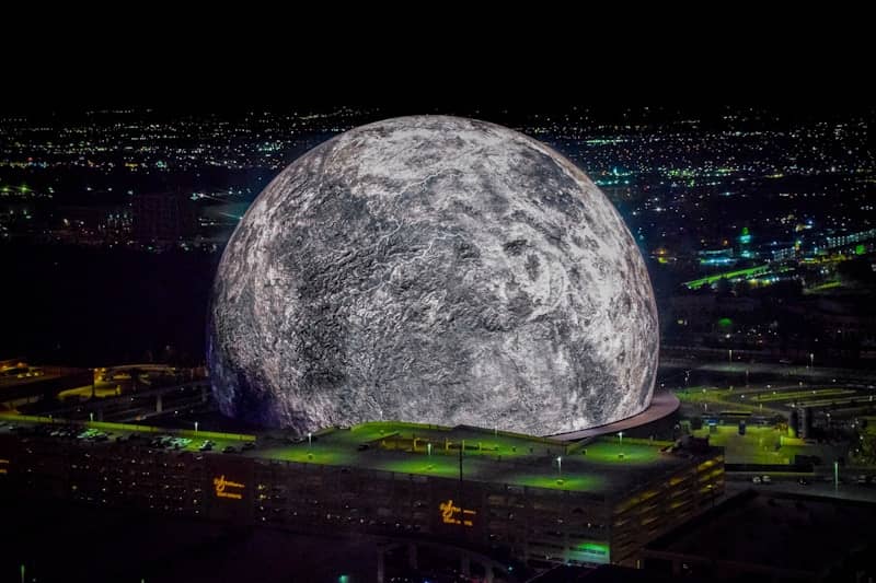 A large moon over a city at night