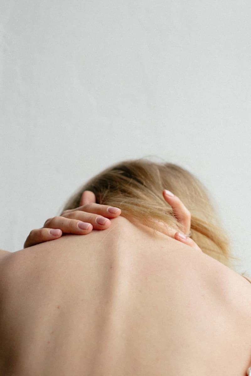 woman covering her neck with her hands
