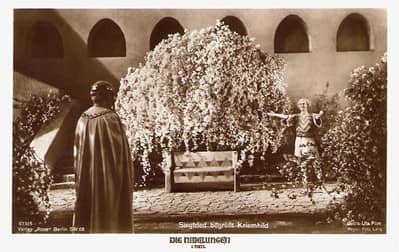 Black-and-white still from the Fritze Lang 1924 movie. This depicts Sifrid and Kriemhilde in a flowering garden some time after their marriage. 