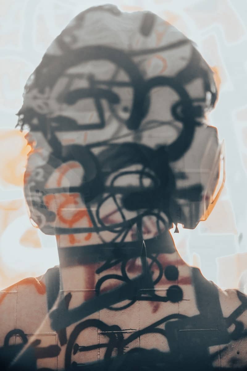 Abstract graffiti art overlaid on a person's head.