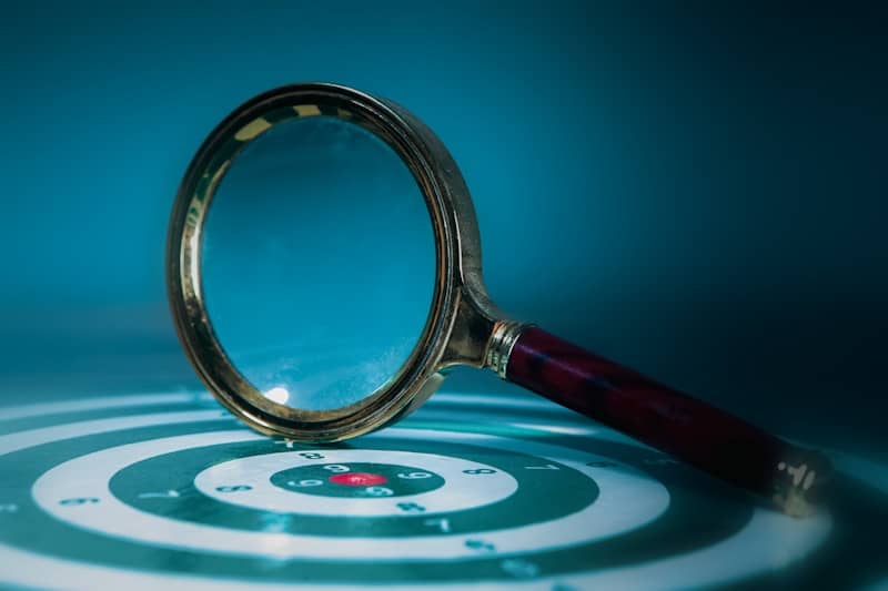 Magnifying glass over a target with bullseye.
