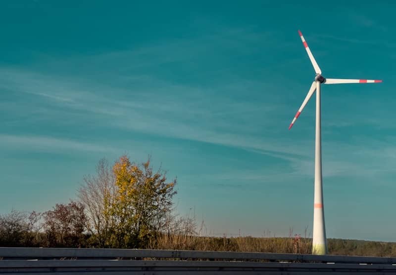 A wind turbine sitting on the side of a road