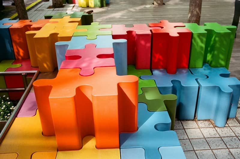 Colorful puzzle piece shaped blocks arranged outdoors.