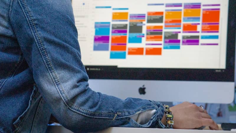 person in blue denim jeans looking at calendar