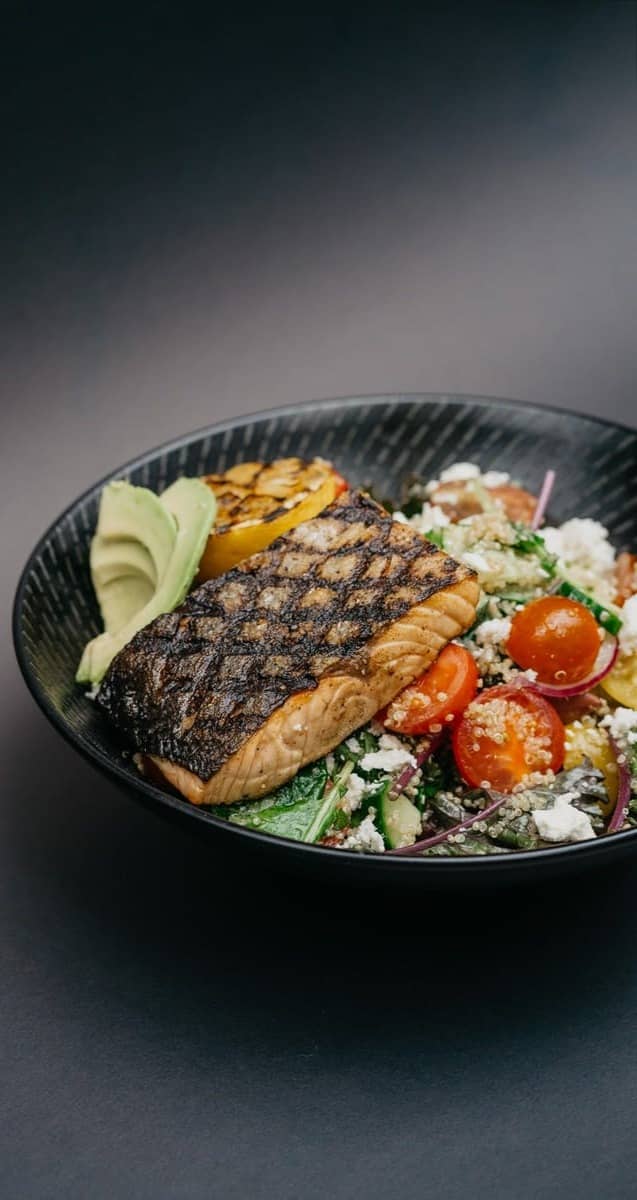 grilled meat with green vegetable on black ceramic plate