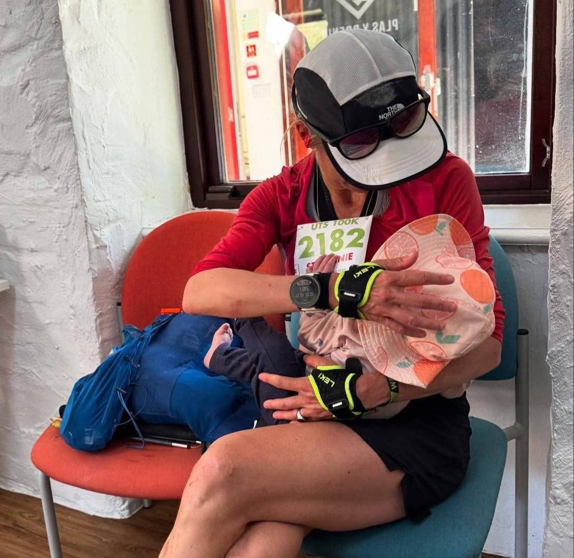Ultramarathon runner Stephanie Case breastfeeds her six-month-old daughter at an aid station.