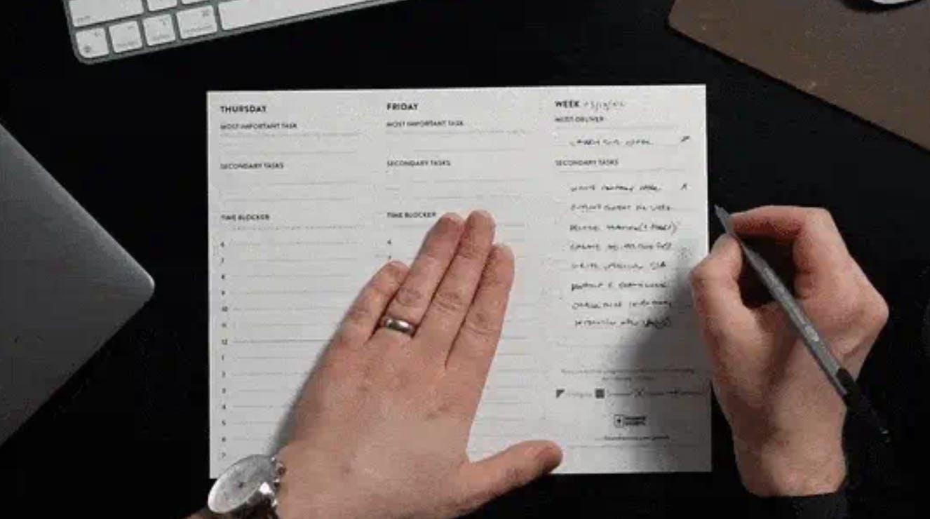 hands writing on timeboxing planner