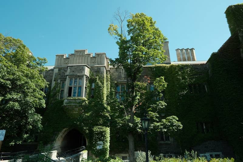 Old ivy-covered stone building with arched entrance.