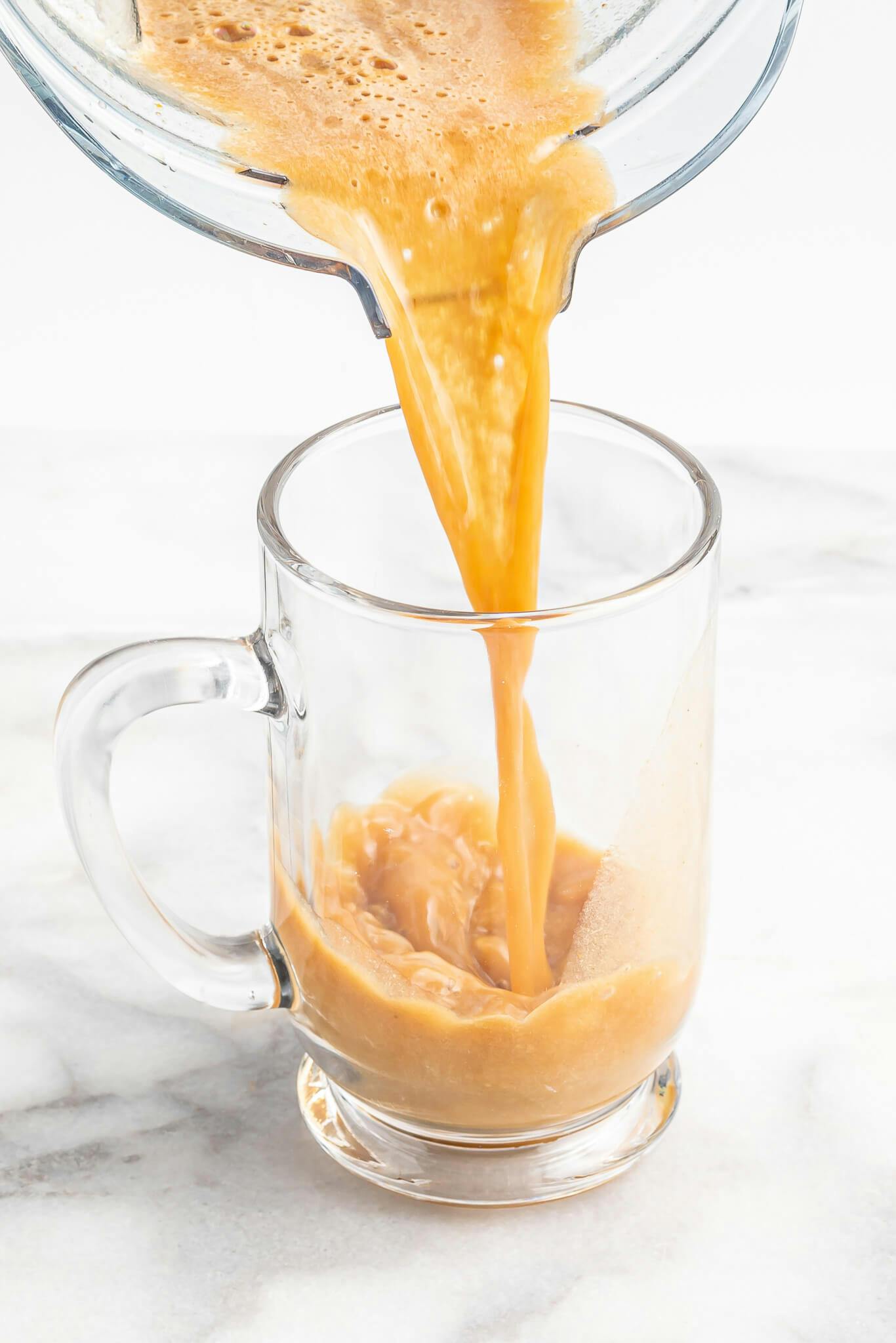 filling a glass mug with a homemade pumpkin spice latte