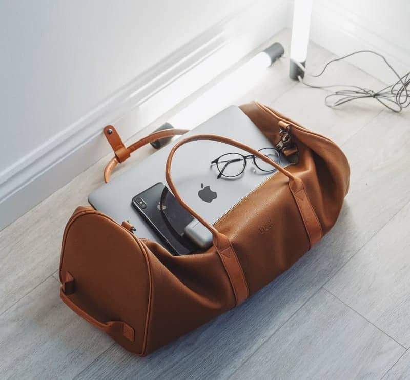 silver MacBook in duffel bag