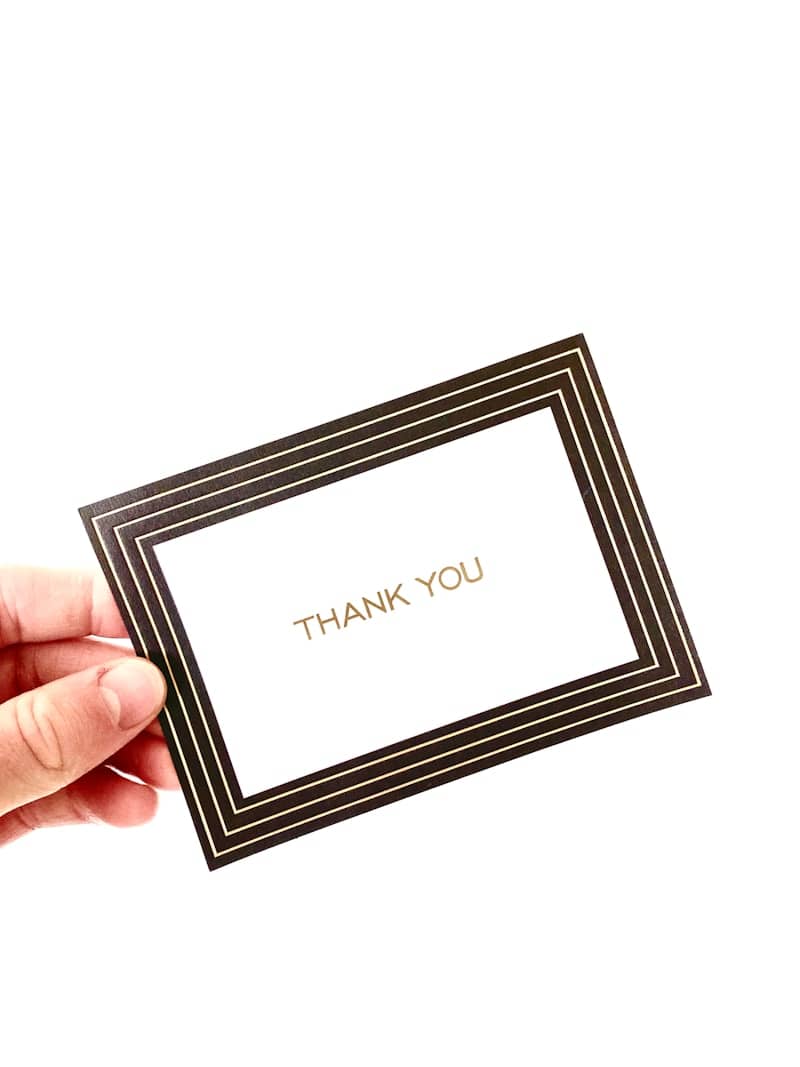 A hand holding a thank card with the words thank you