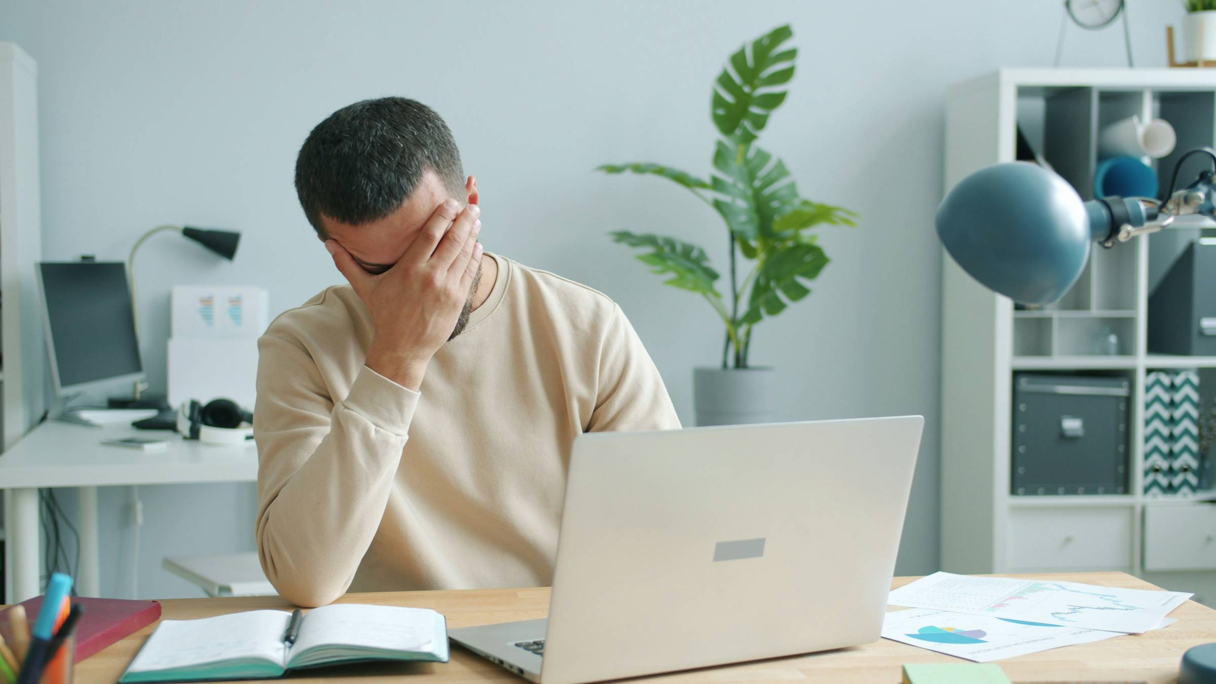 Man with head in hands at a laptop