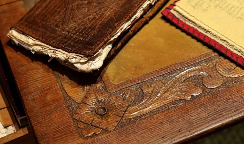 Antique wooden desk with carved details and old books.