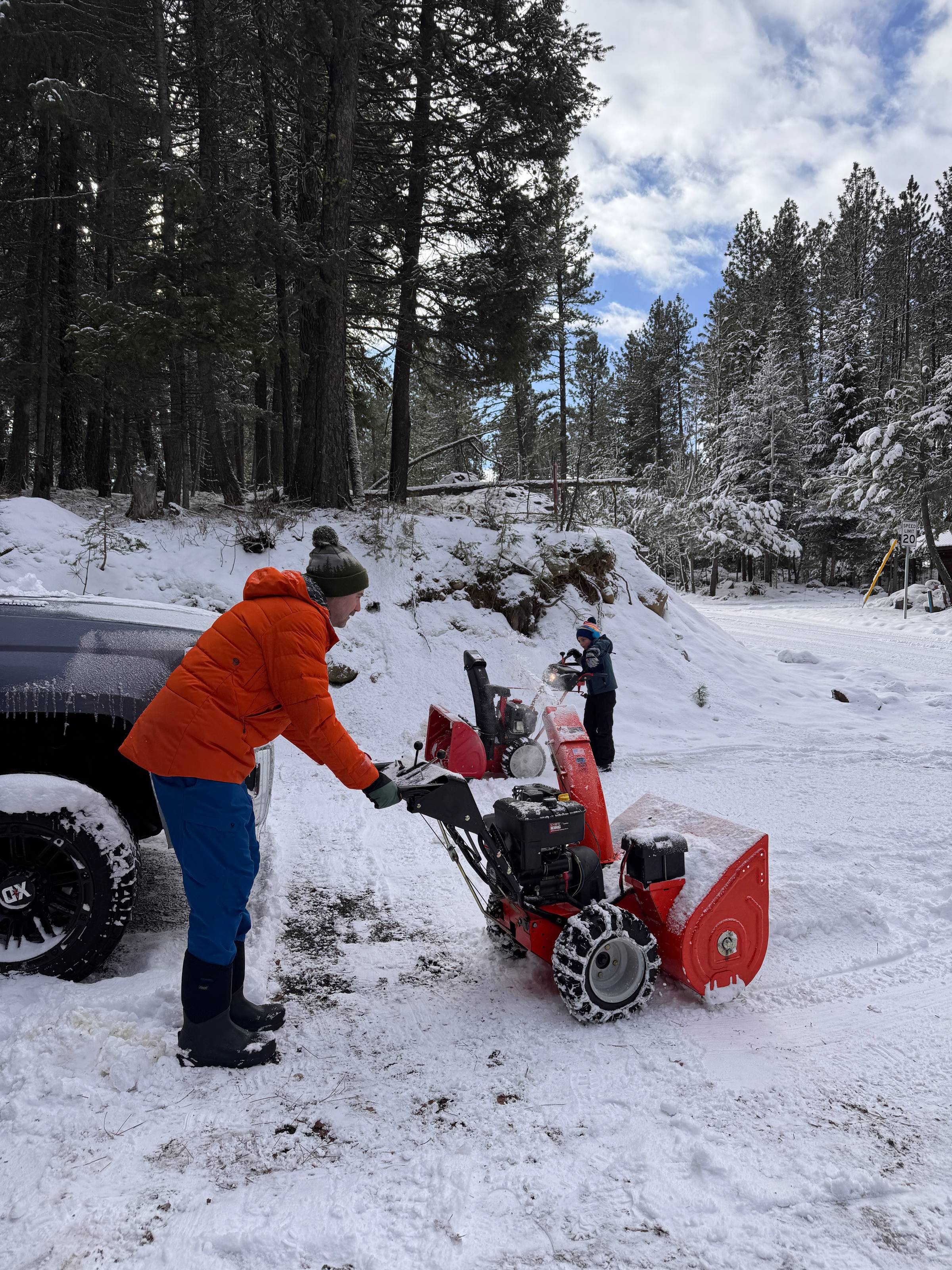 Two people snowblowing a driveway