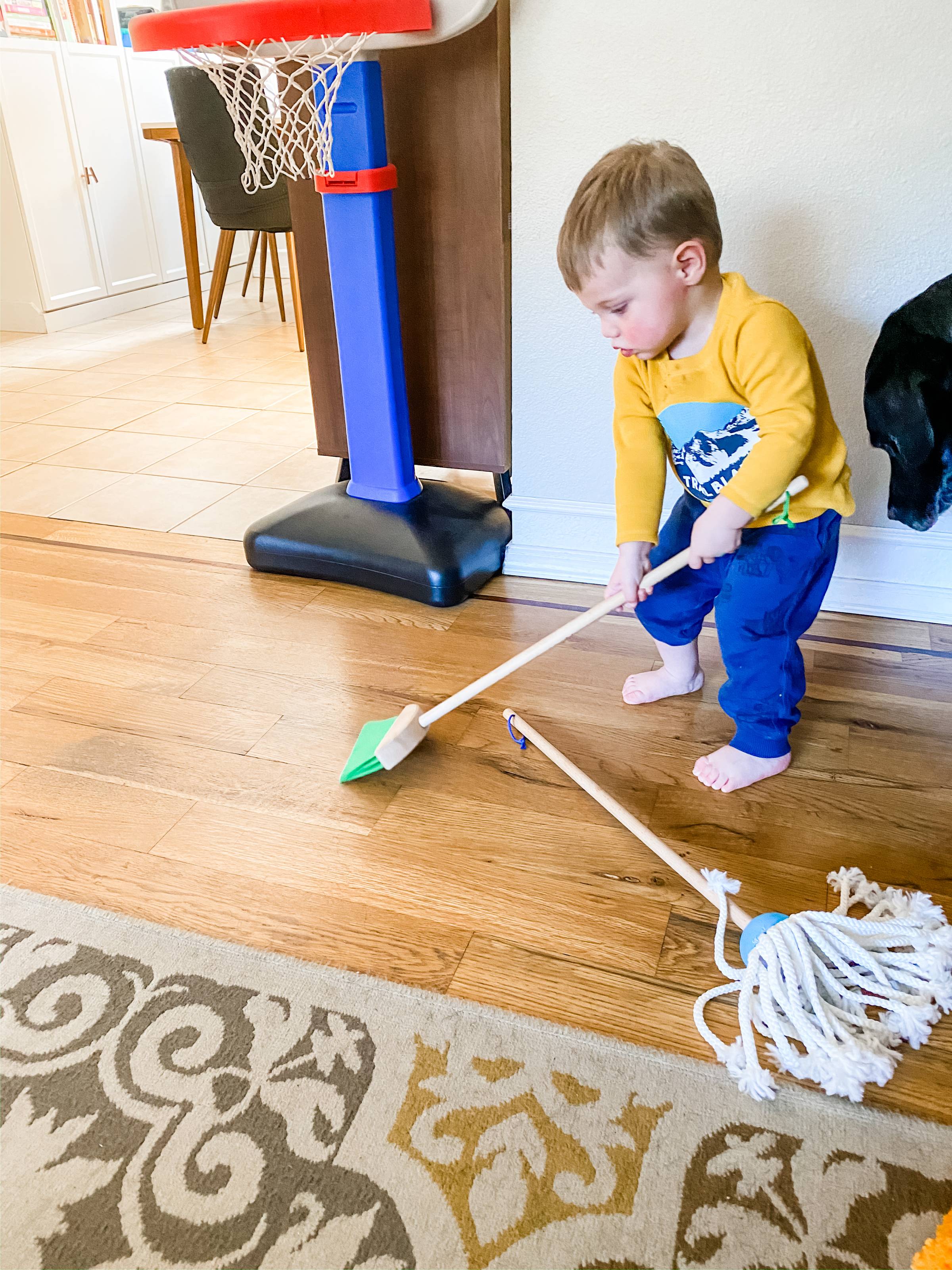 kid sweeping the floor