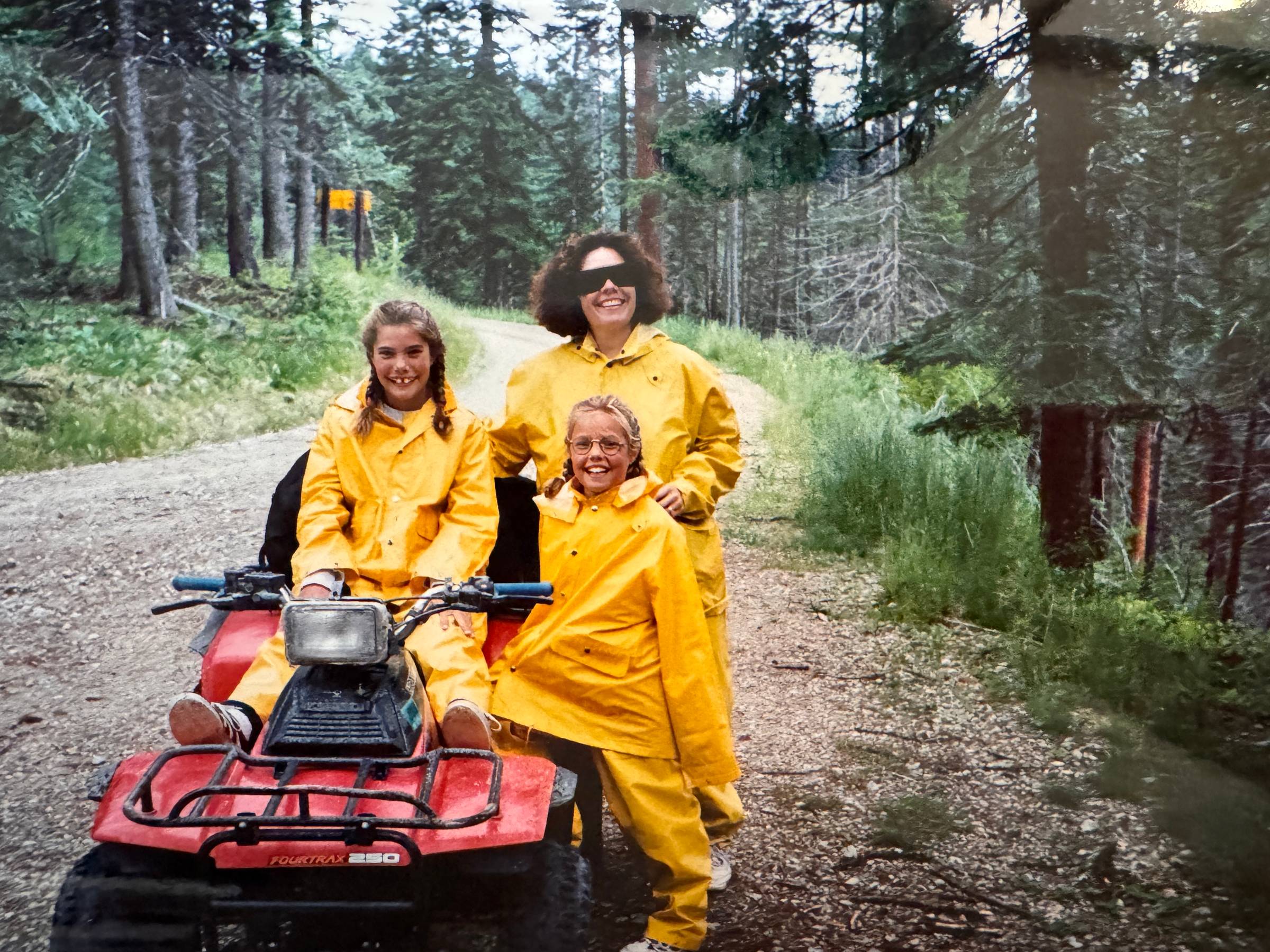 three girls in yellow rain suits on an ATV