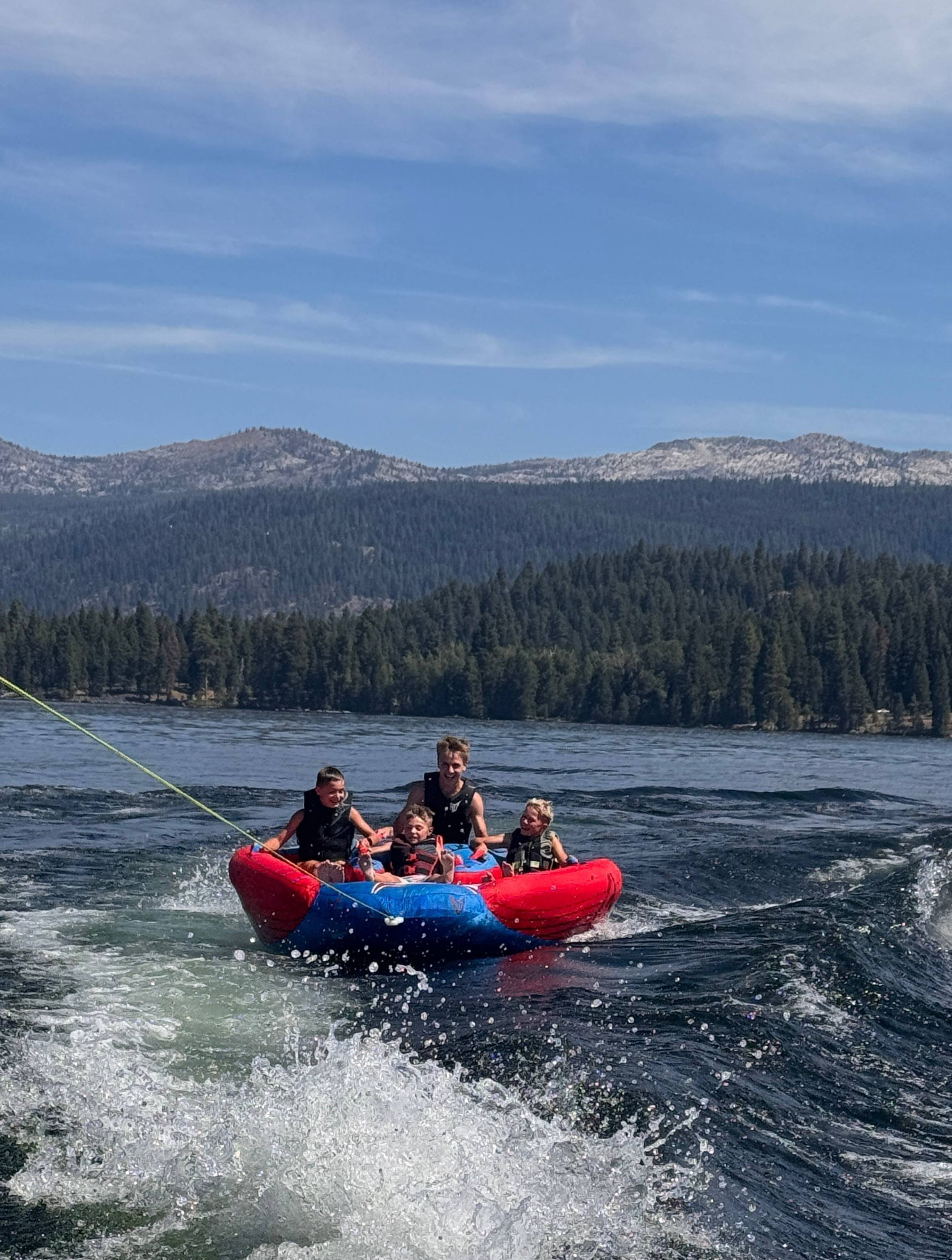Kids on a tube behind a boat