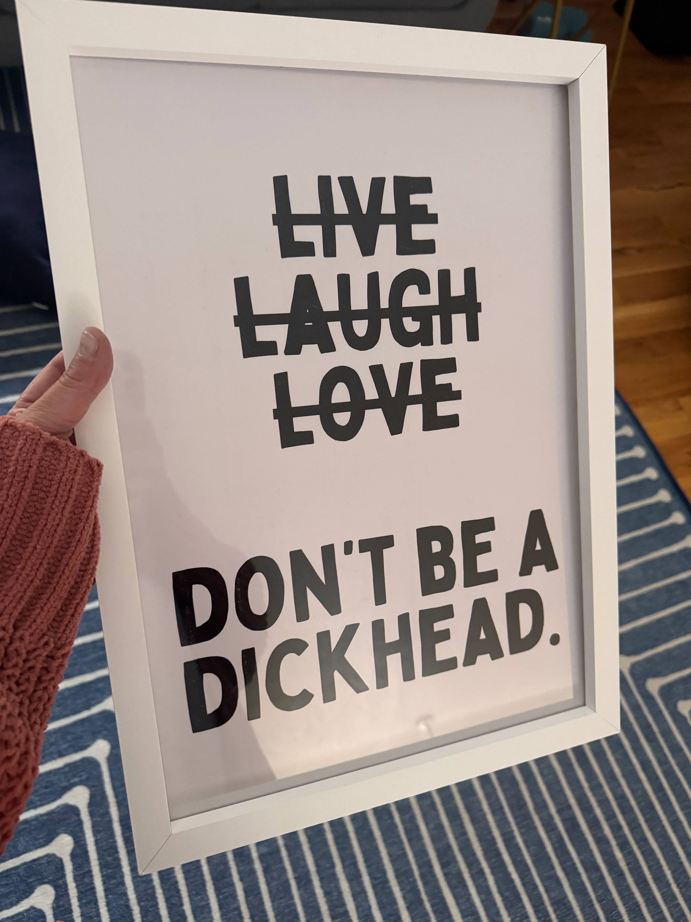 Sign that has "Live Laugh Love" crossed out