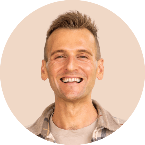 Kaleb Wyse standing in front of peach colored background.