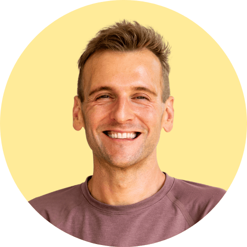 Kaleb Wyse standing in front of yellow background.