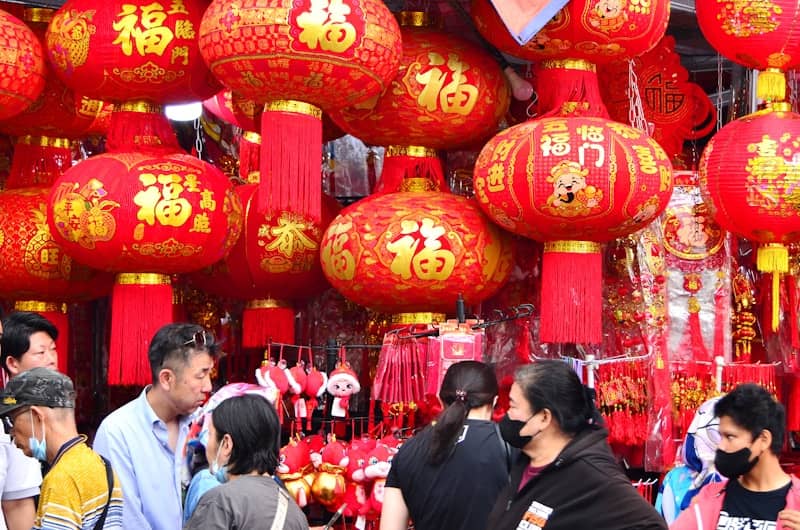 A group of people standing around a store with red lanterns