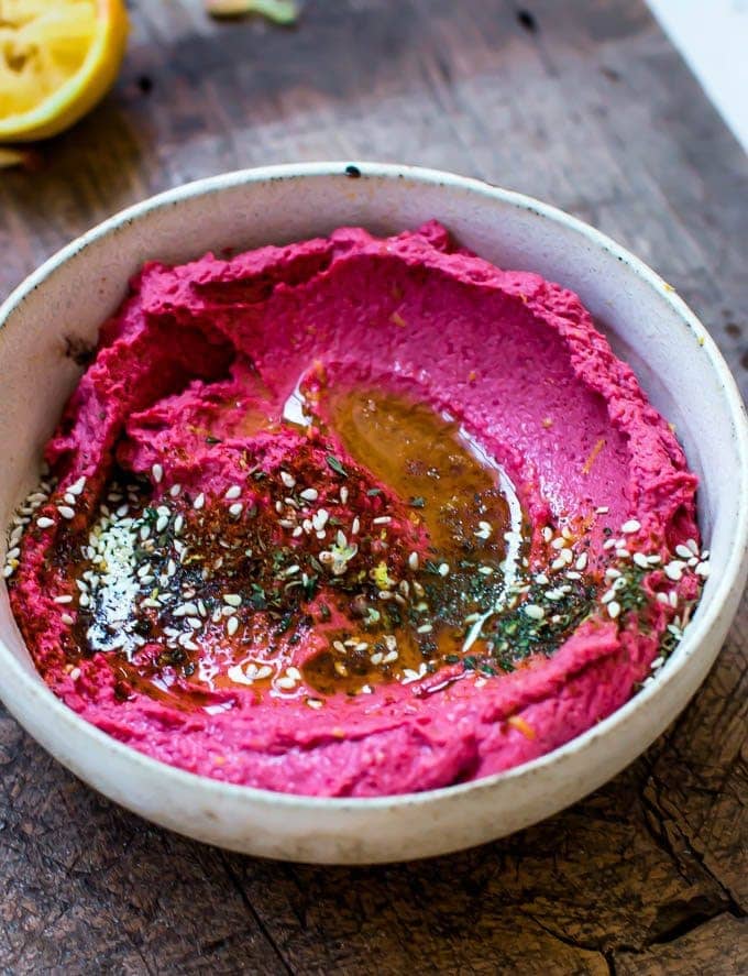Fresh beetroot hummus with a drizzle of olive oil and seasonings.