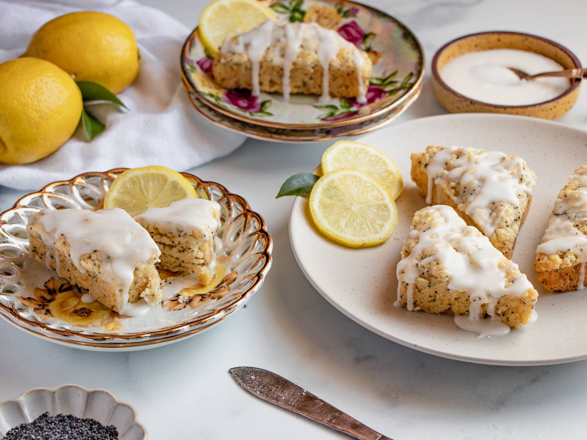 Lemon scones on vintage floral plates surrounded by fresh citrus.