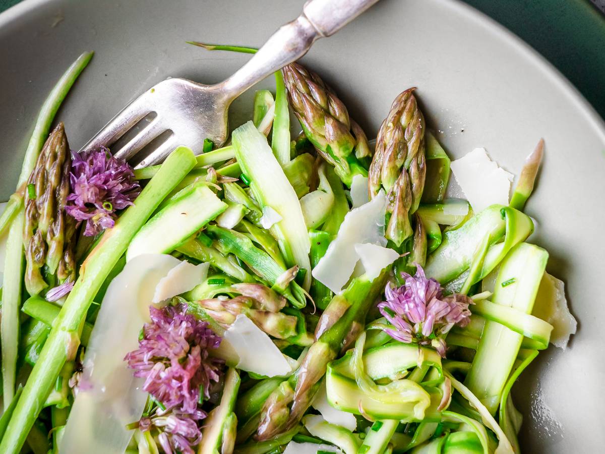 Fresh asparagus salad with chive blossoms and parmesan cheese.