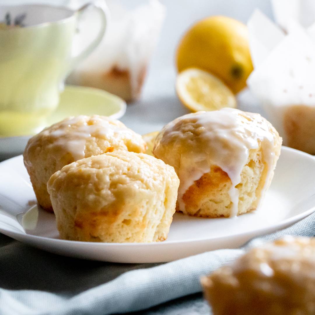 Lemon muffins coated in a lemon glaze.