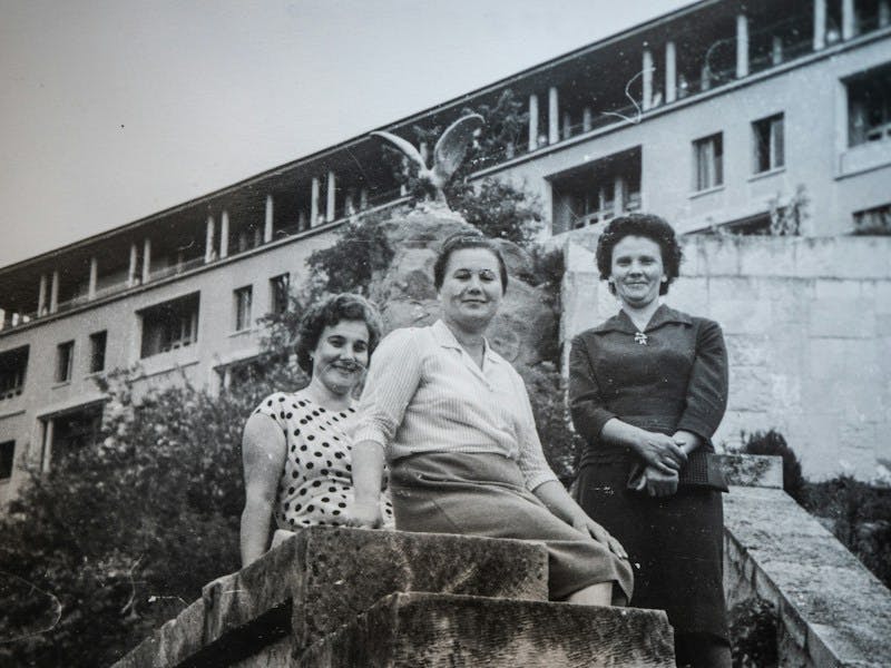 a group of women standing next to each other in front of a building