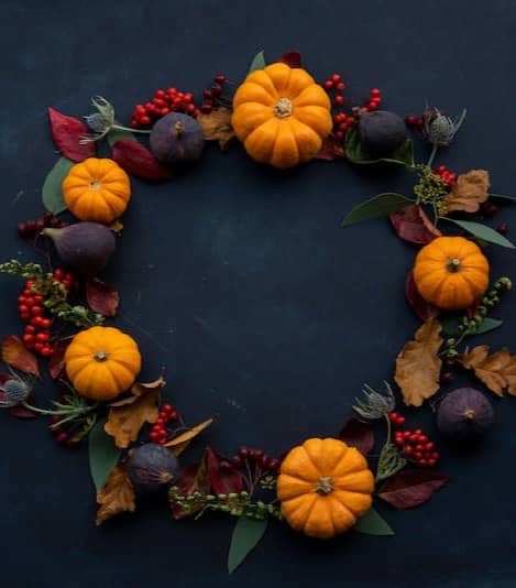 round Halloween-themed wreath on blue surface
