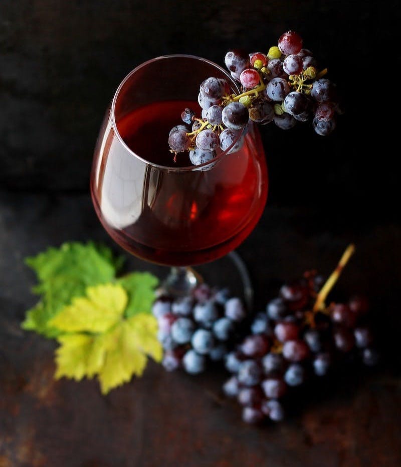 red grapes on clear glass wine