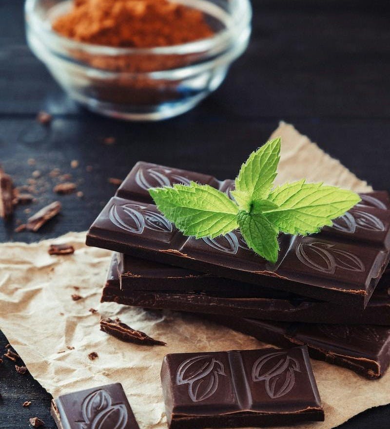 a pile of chocolate with a green leaf on top of it