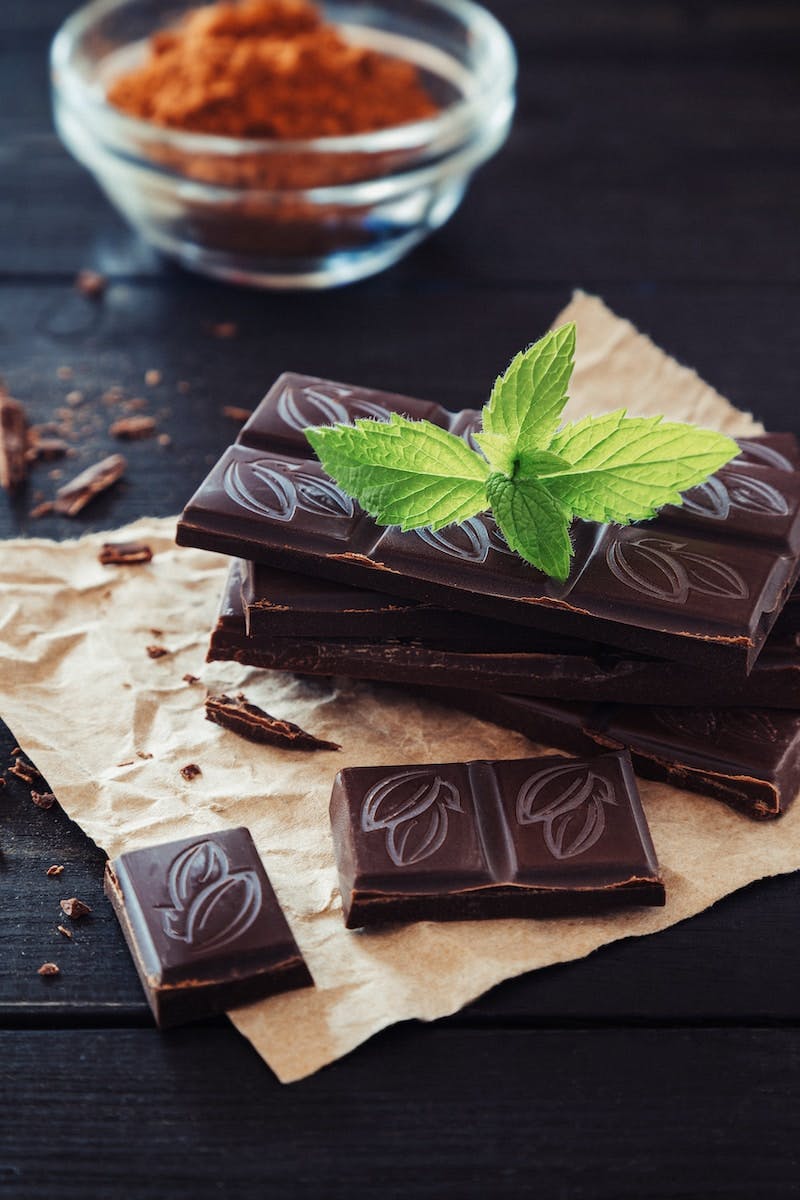 a pile of chocolate with a green leaf on top of it