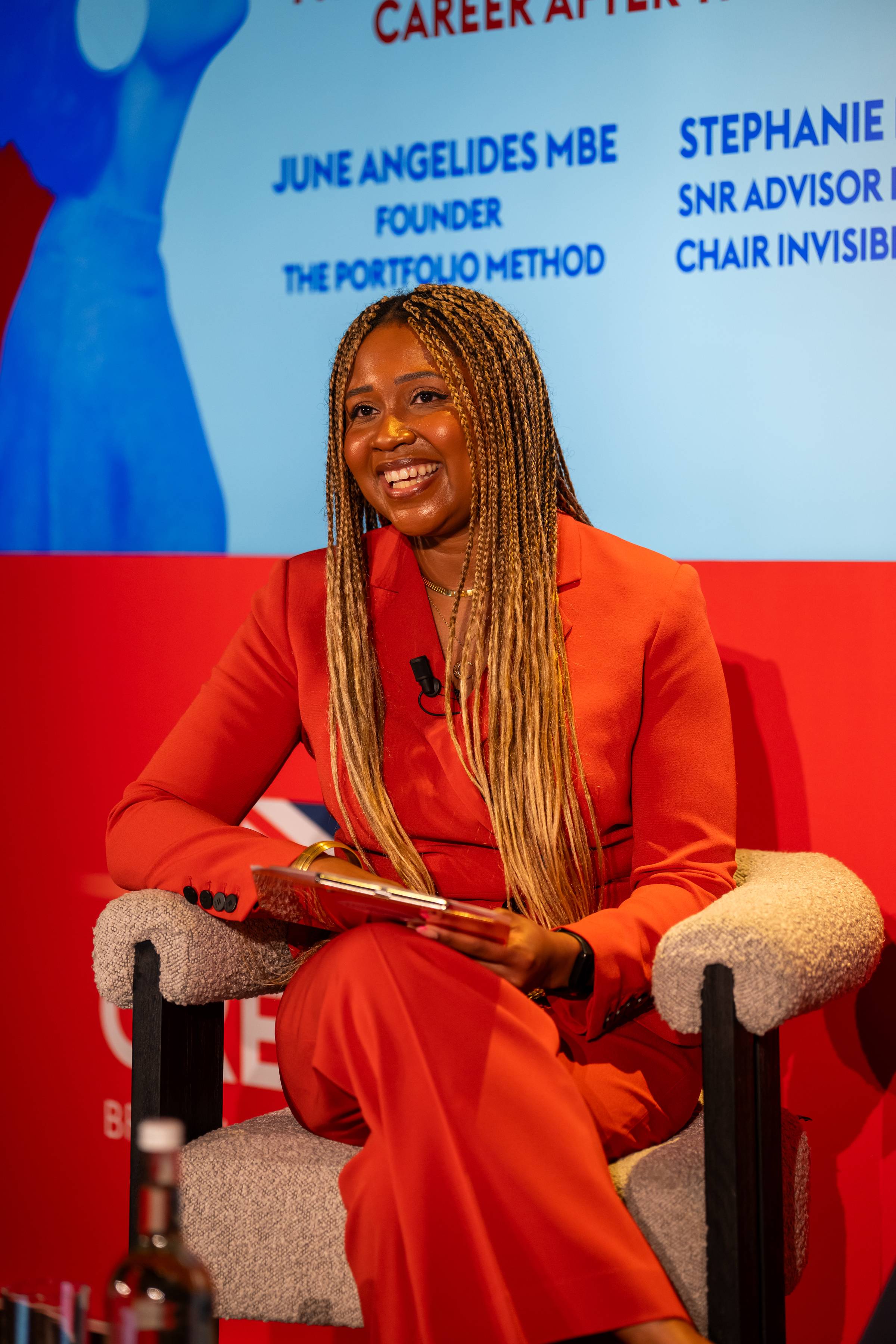 June Angelides MBE, Founder of The Portfolio Method, speaking on stage at a career panel event.