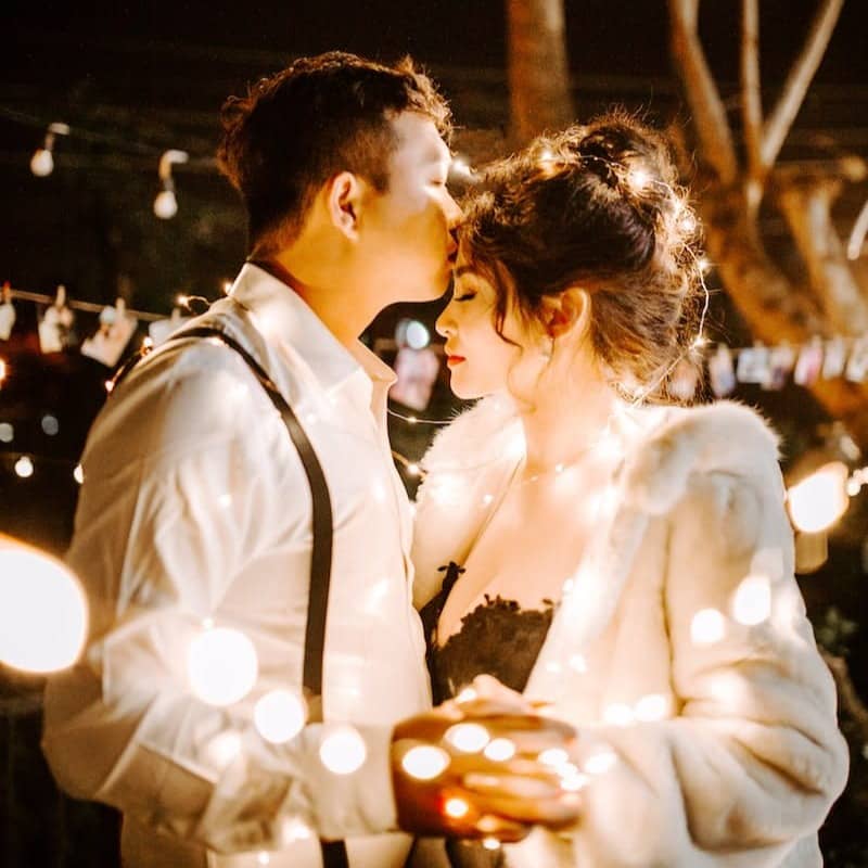 man kissing woman's forehead