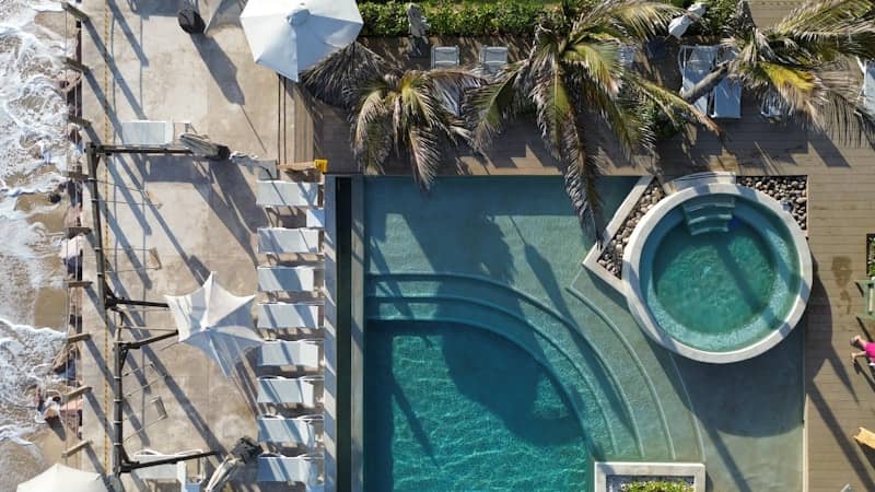Aerial view of a beach resort's pool and jacuzzi.