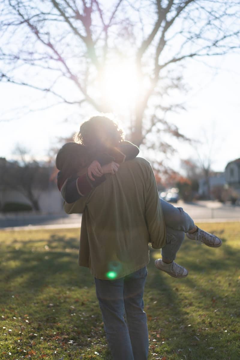 Man carries another person towards the sun.