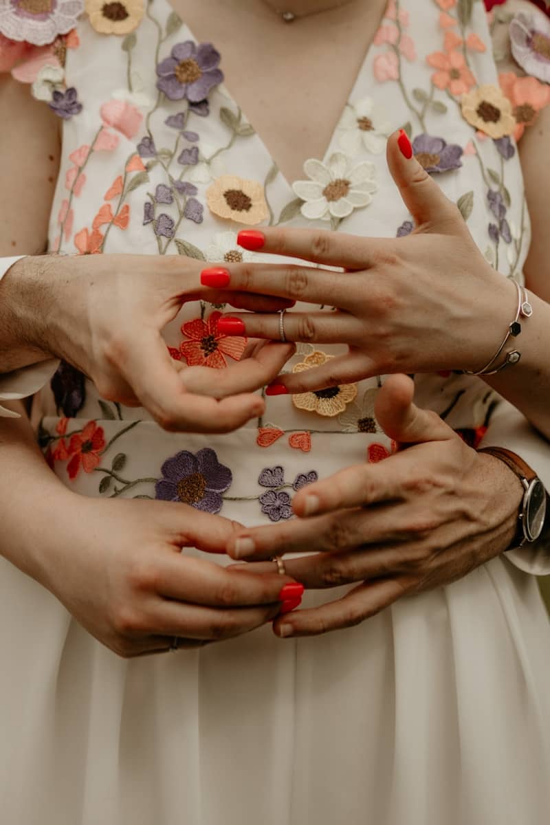A man is putting a ring on a woman's finger.