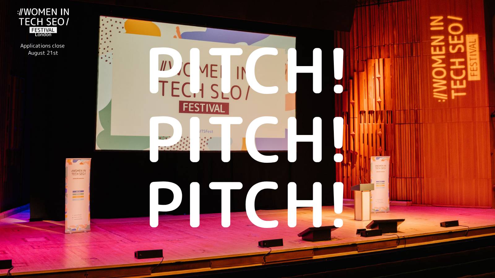Wide view of the WTSFest stage inside a large auditorium with Women in Tech SEO branding on both sides. Large white text reading “PITCH! PITCH! PITCH!” is overlaid across the stage, encouraging speaker applications.