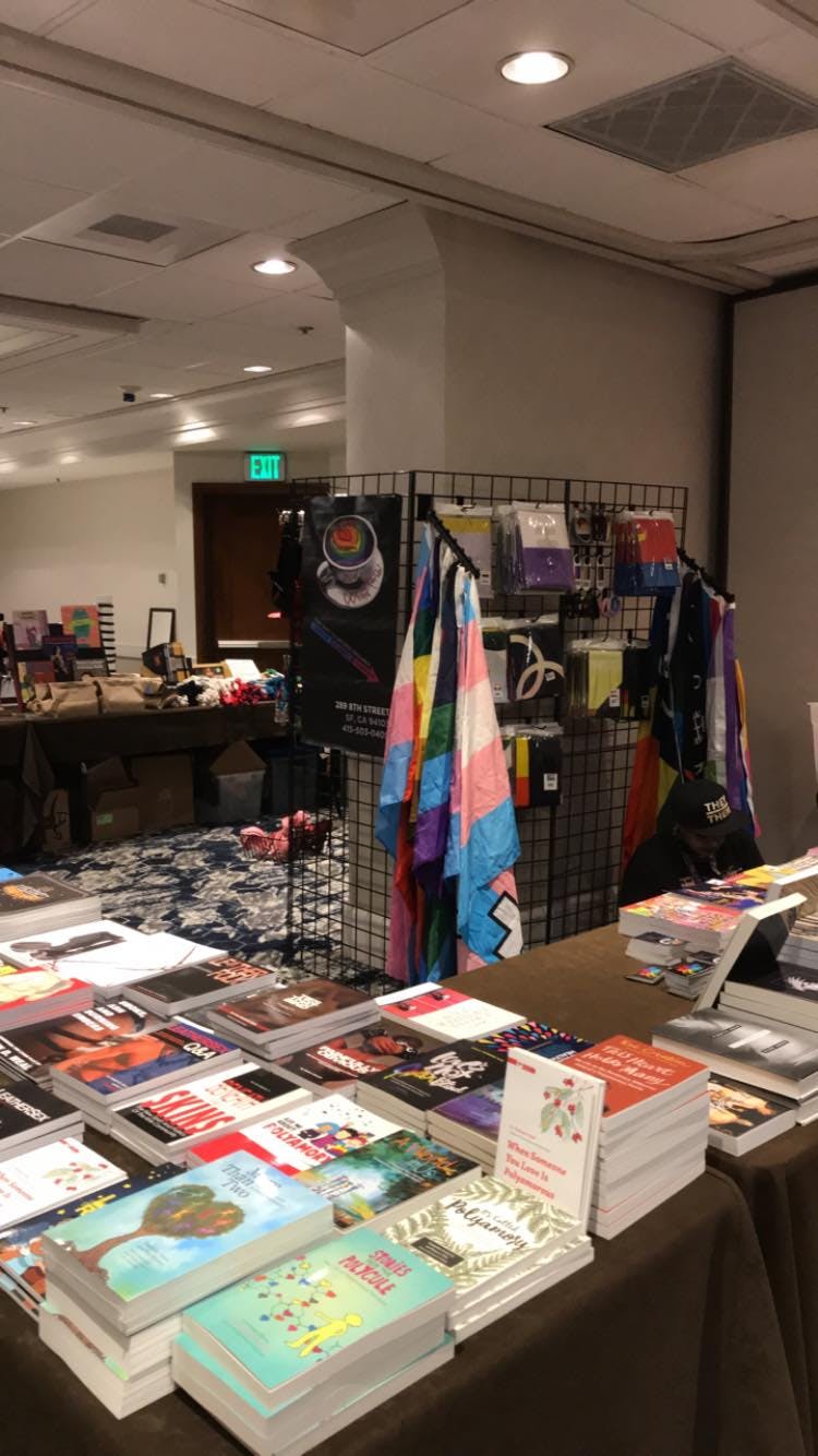 A book table from our vending at IMsL in San Jose a few years back with dozens of books face up on conference tables