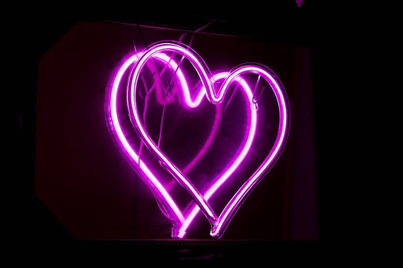 A heart shaped neon sign in the dark