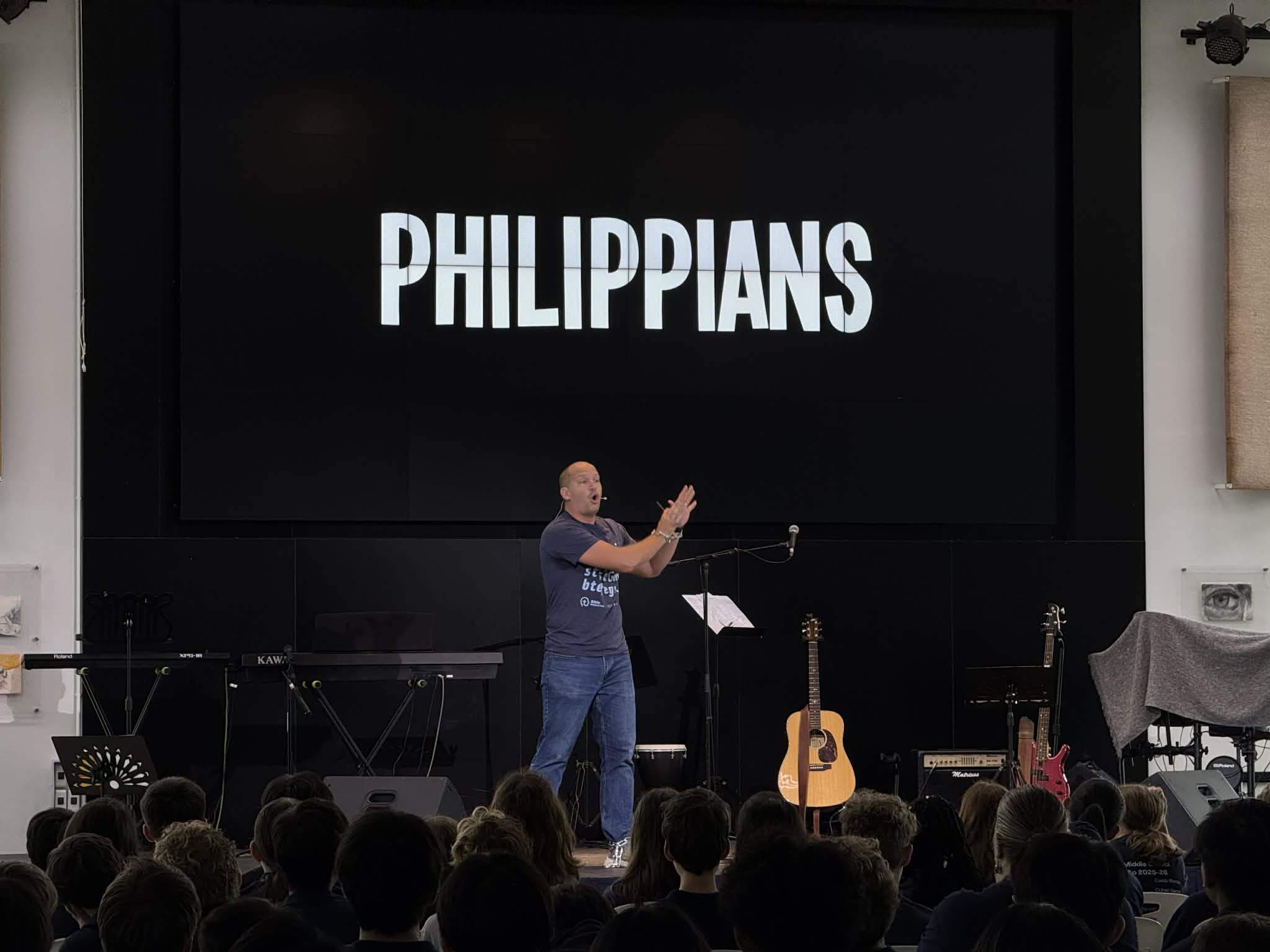 Josh on stage with chains on his hands, reciting the book of Philippians