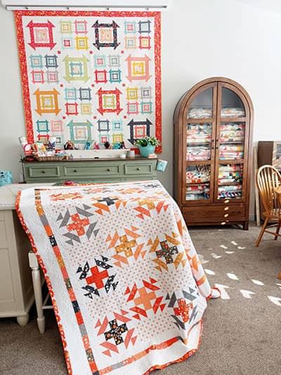 A Quilting Life Sewing Studio with Sunnyside quilt on the wall and Crossroads quilt on the table