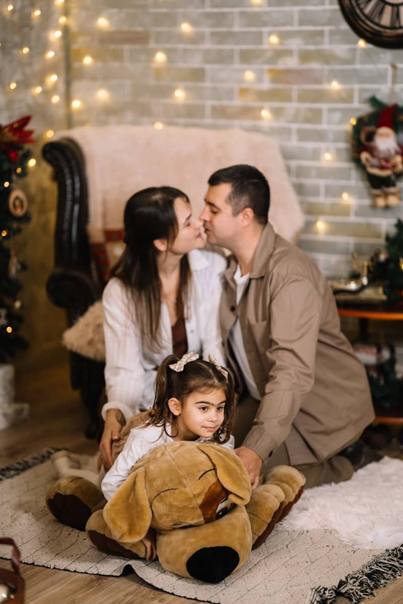 A man and a woman sitting on the floor with a little girl